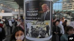 រូបឯកសារ៖ ក្រុម​បាតុករ​ហុងកុងនាំ​គ្នា​បិត​ស្លាកសញ្ញា​មួយ​បង្ហាញ​ពី​រូប​ប្រធានាធិបតី​សហរដ្ឋអាមេរិក​លោក Donald Trump នៅ​លើ​សសរ​មួយ ក្នុង​អំឡុងពេល​តវ៉ា​នៅ​កណ្ដា​លទីក្រុង​ហុងកុង ថ្ងៃទី២៨ ខែវិច្ឆិកា ឆ្នាំ២០១៩។ 