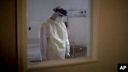 Dr. Juan José Comas visits a patient infected with COVID-19 at the Ezeiza Hospital, southwest of Buenos Aires, Argentina, Thursday, July 16, 2020. (AP Photo/Natacha Pisarenko)