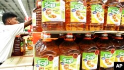 File -- A worker arranges the cooking oil processed with palm oil on display for sale at a hypermarket in Kuala Lumpur, Malaysia.