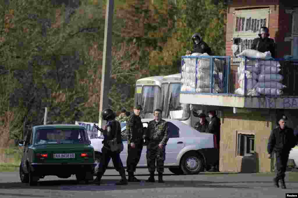 Ukranian troops stand guard at a checkpoint near the city of Izyum in the Kharkiv region of eastern Ukraine, April 15, 2014.