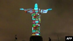Drapeaux des pays touchés par le nouveau coronavirus projetés sur la statue du Christ Rédempteur à Rio de Janeiro, Brésil, 18 mars 2020. (Photo: Forian Plancheur/AFP)
