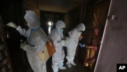 Petugas kesehatan memeriksa orang-orang bergejala Covid-19 di sebuah bangunan tempat tinggal di Dharavi, salah satu daerah kumuh terbesar di Asia, di Mumbai, India, Jumat, 7 Agustus 2020.