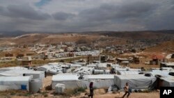 ក្មេងៗ​ភៀស​ខ្លួន​ស៊ីរី​លេង​នៅ​ជំរំ​ជន​ភៀស​ខ្លួន ដែល​ស្ថិត​នៅ​ចន្លោះ​ផ្ទះ និង​អគារ​នានា​នៅ​ក្នុង​ក្រុង Arsal ភាគ​ខាង​កើត​នៃ​ប្រទេស​លីបង់ ជាប់​នឹង​ព្រំដែន​ស៊ីរី​ កាលពី​ថ្ងៃទី១៣ ខែមិថុនា ឆ្នាំ២០១៨។