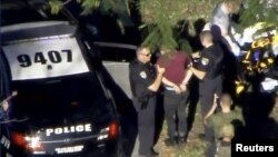 Le suspect Nikolas Cruz arrêté par la police près du lycée Marjory Stoneman Douglas High School à Parkland, en Floride, après la fusillade du 14 février 2018.