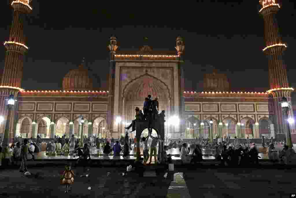 Beberapa anak laki-laki Muslim India bermain di atas marmer setelah berbuka puasa pada hari terakhir bulan suci Ramadhan di Masjid Jama di New Delhi, India (19 Agustus). 