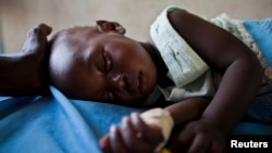 FILE - A young girl with malaria rests in the inpatient ward of the Malualkon Primary Health Care Center in Malualkon, in the South Sudanese state of Northern Bahr el Ghazal.