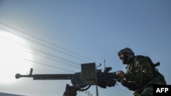 Afghan security personnel and Afghan militia fighting against Taliban stand guard in Enjil district of Herat province on July 30, 2021.