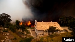 FILE - A fire rages near homes in San Marcos, California May 15, 2014.