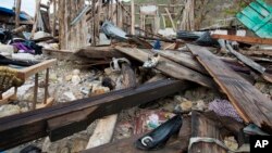 Shoes are scattered among the debris of a home destroyed by Hurricane Matthew, in Port-a-Piment, a district of Les Cayes, Haiti, Oct. 19, 2016. Hopes have dimmed for Haitians combing the countryside for missing relatives in the Caribbean nation’s hardest-hit zone, the remote and long-ignored southwestern tip.