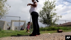 Žena, koja tvrdi da je u SAD ušla nelegalno, gleda svoju ćerku , rođenu u SAD, kako se igra u gradiću Saliven Siti u Teksasu, 16. septembra 2015. godine (Foto: AP/Eric Gay)