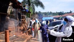 Ugandan health officials wearing protective gear disinfect the Nakawa open-air market as part of the measures to prevent the spread of the coronavirus disease (COVID-19), in Nakawa division of Kampala, April 17, 2020.