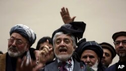 Afghan presidential candidate Abdullah Abdullah, center, addresses the media following a meeting with his party members, in Kabul, Afghanistan, Feb. 18, 2020.