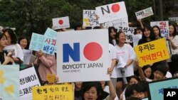 South Korean protesters hold up cards calling for a boycott of Japanese products during a rally demanding full compensation and an apology for wartime sex slaves from Japan in front of the Japanese Embassy in Seoul, South Korea, July 31, 2019.