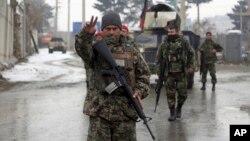 Afghan national army soldiers stand guard at the entrance gate of Marshal Fahim military academy in Kabul, Afghanistan, Monday, Jan. 29, 2018. Militants attacked an Afghan army unit guarding the military academy on Monday, officials said. Hours later, the Islamic State group claimed responsibility for the assault. (AP Photo/Rahmat Gul)