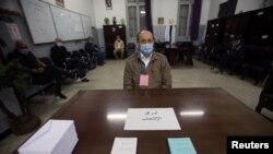 Un électeur portant un masque facial pour se protéger contre la maladie à coronavirus (COVID-19), dans un bureau de vote pendant le référendum constitutionnel à Alger, en Algérie, le 1er novembre 2020.