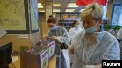 Anggota komisi pemilihan lokal bersiap-siap memberikan suara pada hari pertama pemilihan parlemen di Vladivostok, Rusia, 17 September 2021. (REUTERS/Tatiana Meel)