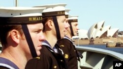 FILE - Sailors onboard Australia's HMAS Stuart line the upper decks as the ship sails towards the Sydney Opera House on returning from duty in the Middle East, Sept. 10, 2004. 
