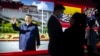 People gather near a display featuring a photo of Chinese President Xi Jinping at the Potala Palace in Beijing, Oct. 20, 2021.