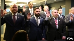 A group of military veterans take the oath at a U.S. Immigration and Customs Enforcement (ICE) ceremony, swearing them in to serve as analysts on child exploitation cases, at ICE headquarters in Washington, March 31, 2017. (B. Hamdard/VOA)