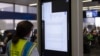 A technician works on an information display near United Airlines gates at Chicago O'Hare International Airport in Chicago, July 19, 2024, after a faulty CrowdStrike update caused a major internet outage for computers running Microsoft Windows. 