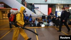 Seorang petugas yang menggunakan pakaian hazmat menyemprotkan disinfektan di area Stasiun Kereta Api Leningradsky di Moskow tengah merebaknya penyebaran COVID-19 di Rusia pada 19 Oktober 2021. (Foto: Reuters: Maxim Shemetov)
