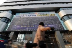 A woman walks past a branch of the Shincheonji Church of Jesus the Temple of the Tabernacle of the Testimony where a woman known as "Patient 31" attended a service in Daegu, South Korea, Feb. 19, 2020.