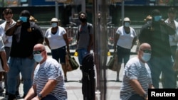 People wear masks to prevent against the spread of coronavirus disease (COVID-19), as the highly transmissible Delta variant has led to a surge in infections, in New York City, U.S., July 30, 2021. 