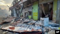 Debris lies on the street outside damaged shops in Chinatown, Honiara, Solomon Islands, Friday, Nov. 26, 2021. (AP Photo/Piringi Charley)