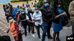 FILE - People wait to register for the first injection of the Oxford/AstraZeneca COVID-19 vaccine during the launch of a vaccination campaign, at the Kenyatta International Convention Centre in Nairobi, Kenya, April 21, 2021.