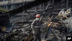 Seorang pekerja membersihkan puing-puing di pembangkit listrik milik DTEK yang terkena rudal Rusia di Ukraina, pada Selasa, 2 April 2024. (Foto: AP)