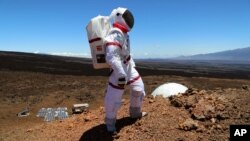 In this June 4 2013 photo provided by the University of Hawaii, research space scientist Oleg Abramov walks outside simulated Martian base at Mauna Loa, Hawaii. Six researchers have spent the past four months living in a small dome on a barren Hawaii lava field at 8,000 feet, trying to figure out what foods astronauts might eat on Mars and during deep-space missions. (AP Photo/University of Hawaii, Angelo Vermeulen)