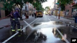 미국 펜실베이니아주 필라델피아의 '사우스스트리트' 거리에서 소방관이 5일 호스를 이용해 전날 발생한 총격 현장의 핏자국을 씻어내고 있다. 