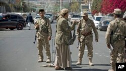 Shi'ite Yemeni Houthi, wearing army uniforms stand guard on a street leading to the presidential palace in Sana'a, Jan. 21, 2015.