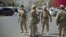 Shi'ite Yemeni Houthi, wearing army uniforms stand guard on a street leading to the presidential palace in Sana'a, Jan. 21, 2015.