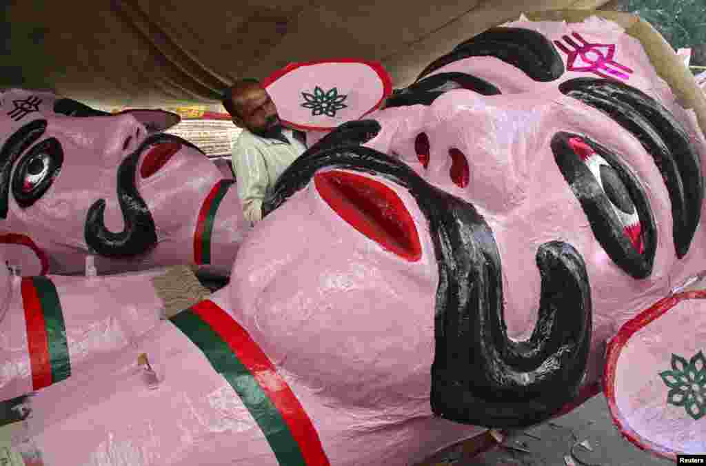 An artisan shows an effigy of demon king Ravana, to a customer (not pictured) in preparation for the upcoming Hindu festival of Dussehra in Chandigarh, India. Effigies of the 10-headed demon king are burnt on Dussehra, the Hindu festival that commemorates the triumph of Lord Rama over the Ravana, marking the victory of good over evil.