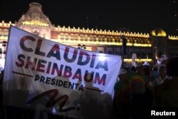 Orang-orang memegang spanduk bertuliskan 'Presiden Claudia Sheinbaum' setelah Partai Morena yang berkuasa di Meksiko menyatakan Claudia Sheinbaum sebagai pemenang pemilihan presiden, di Zocalo Square di pusat Kota Mexico City, Meksiko 2 Juni 2024. (Foto: REUTERS/Mahe Elipe)