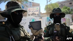 18일 이라크 시아파 군이 남부 도시 바스라 본부 인근에서 경계 근무를 서고 있다. 시아파 군대는 이라크 정부군이 ISIL에 빼앗긴 라마디 재탈환 적전에 투입되었다.