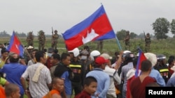 រូបឯកសារ៖ មន្ត្រី​ទាហាន​កម្ពុជា​ឈរ​យាម​ខណៈ​ដែល​​អ្នក​គាំទ្រ​គណបក្ស​សង្គ្រោះ​ជាតិ​មក​ដល់​ព្រំដែន​កម្ពុជា-វៀតណាម​ ក្នុង​អំឡុង​ពេល​​ទស្សនកិច្ច​​ចុះ​ត្រួត​ពិនិត្យ​ព្រំដែន​នៅ​ខេត្ត​ស្វាយរៀង​កាល​ពី​ថ្ងៃ​ទី​១៩ ខែ​កក្កដា ឆ្នាំ​២០១៥។