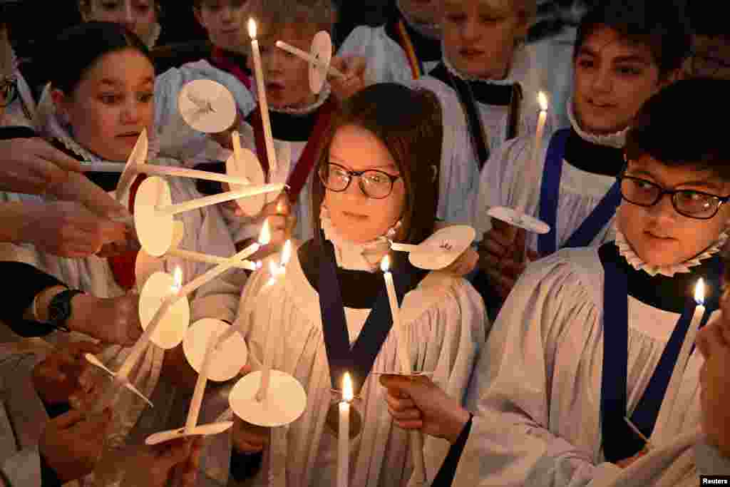 Choristers light candles during a rehearsal for Christmas services at St. Paul&#39;s Cathedral in London, Britain. St. Paul&#39;s choir includes girls for the first time in its 900-year history.