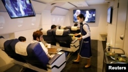 A staff dressed as a flight attendant serves meals to customers at First Airlines, that provides VR flight experiences, including 360-degree tours of cities and meals, amid the COVID-19 pandemic in Tokyo, Japan August 12, 2020. (REUTERS/Kim Kyung-Hoon)