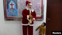 2018年12月22日，中国云南省鹿泉彝族苗族自治县的基督教堂，一个男孩看着圣诞老人像。