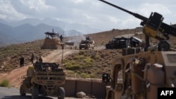 FILE - In this photo taken on July 7, 2018, US Army from NATO and Afghan commando forces are pictures in a checkpoint during a patrol against Islamic State militants at the Deh Bala district in the eastern province of Nangarhar Province.