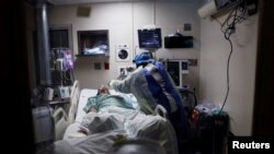 រូបឯកសារ៖ អ្នកស្រី Paula Johnson ជា​គិលានុបដ្ឋាយិកា មើល​អ្នកជំងឺ​កូវីដ១៩ ដែល​កំពុង​ទទួល​ការព្យាបាល​នៅក្នុង​មន្ទីរពេទ្យសហគមន៍ Roseland នៅ​ក្នុង​ទីក្រុង Chicago រដ្ឋ Illinois សហរដ្ឋ​អាមេរិក កាលពី​ថ្ងៃទី២២ ខែមេសា ឆ្នាំ២០២០។