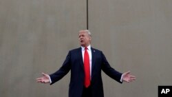 FILE - President Donald Trump speaks during a tour as he reviews border wall prototypes in San Diego, California, March 13, 2018.