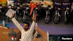 Aamir Liaquat Hussain, host of the Geo TV channel program "Amaan Ramazan", gestures while asking participants questions during a live show in Karachi, July 26, 2013. 