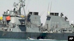 FILE - In this Oct. 15, 2000 file photo, experts in a speed boat examine the damaged hull of the USS Cole at the Yemeni port of Aden after an al-Qaida attack that killed 17 sailors.