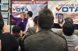 Former Secretary of Housing and Urban Development and former presidential candidate Julián Castro introduces Massachusetts Senator Elizabeth Warren to a standing ovation at Cardenas Market in East Las Vegas. (Carolyn Presutti/VOA)