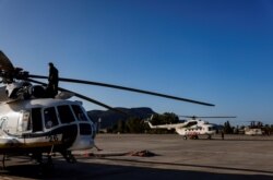 A technician makes the last checks before a firefighting helicopter takes off for a wildfire near Marmaris, Turkey, Aug. 3, 2021.