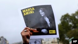 FILE - Seorang pengunjuk rasa di Paris, Prancis, menunjukkan potret Mahsa Amini saat berlangsungnya aksi solidaritas untuk mendukung pengunjuk rasa Iran atas kematian seorang wanita muda dalam tahanan polisi, Minggu, 2 Oktober 2022. (AP/Aurelien Morissard)
