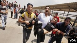 Warga Palestina membawa seorang rekan mereka yang ditembak oleh polisi Israel dalam bentrokan di perbatasan Gaza (15/5).